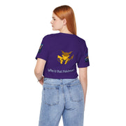 Person wearing a purple t-shirt with a Pokémon logo and text on the back, standing against a white background.